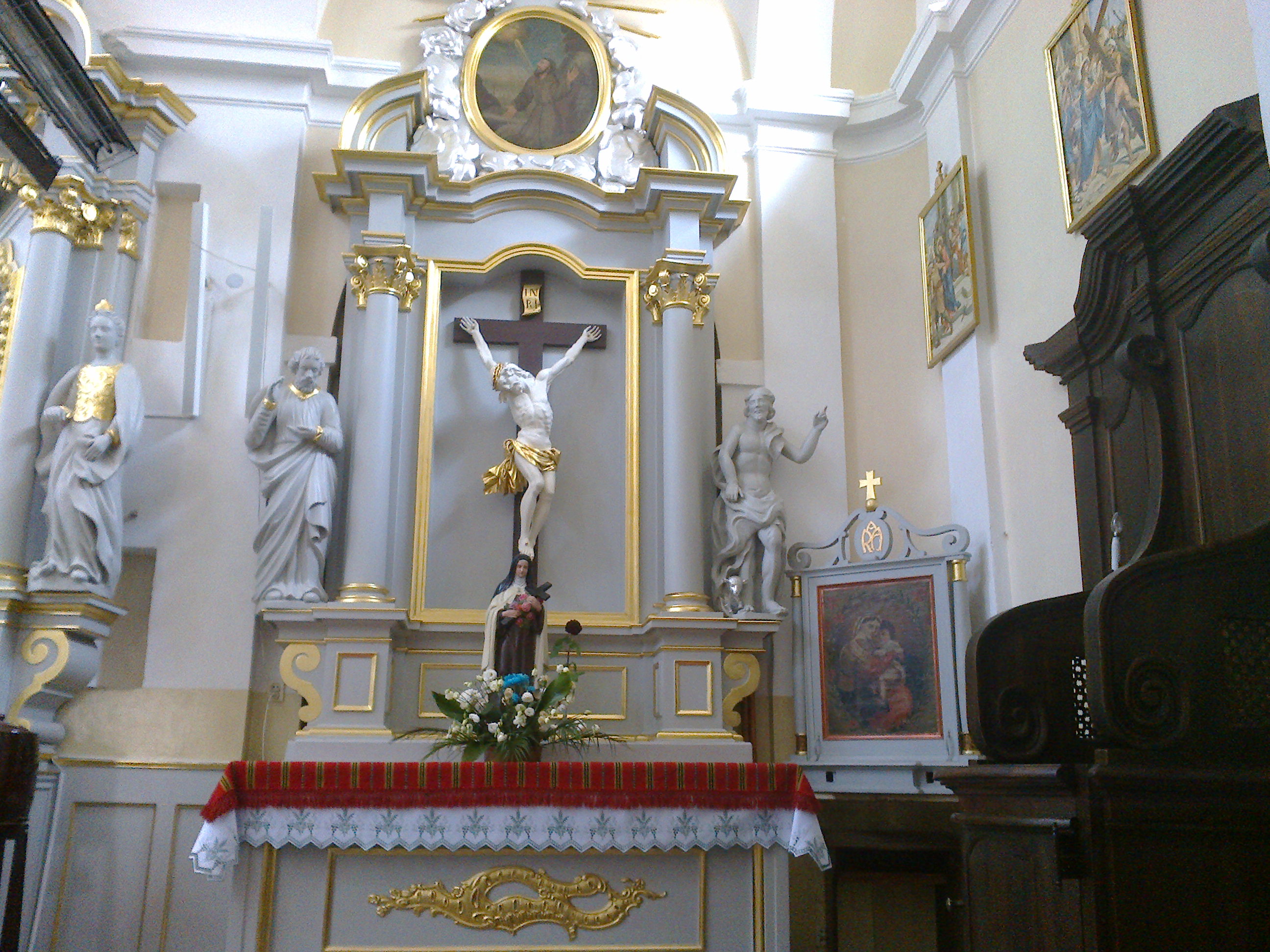 Ołtarz z barokowym krucyfiksem i figurą św. Teresy z Lisieux